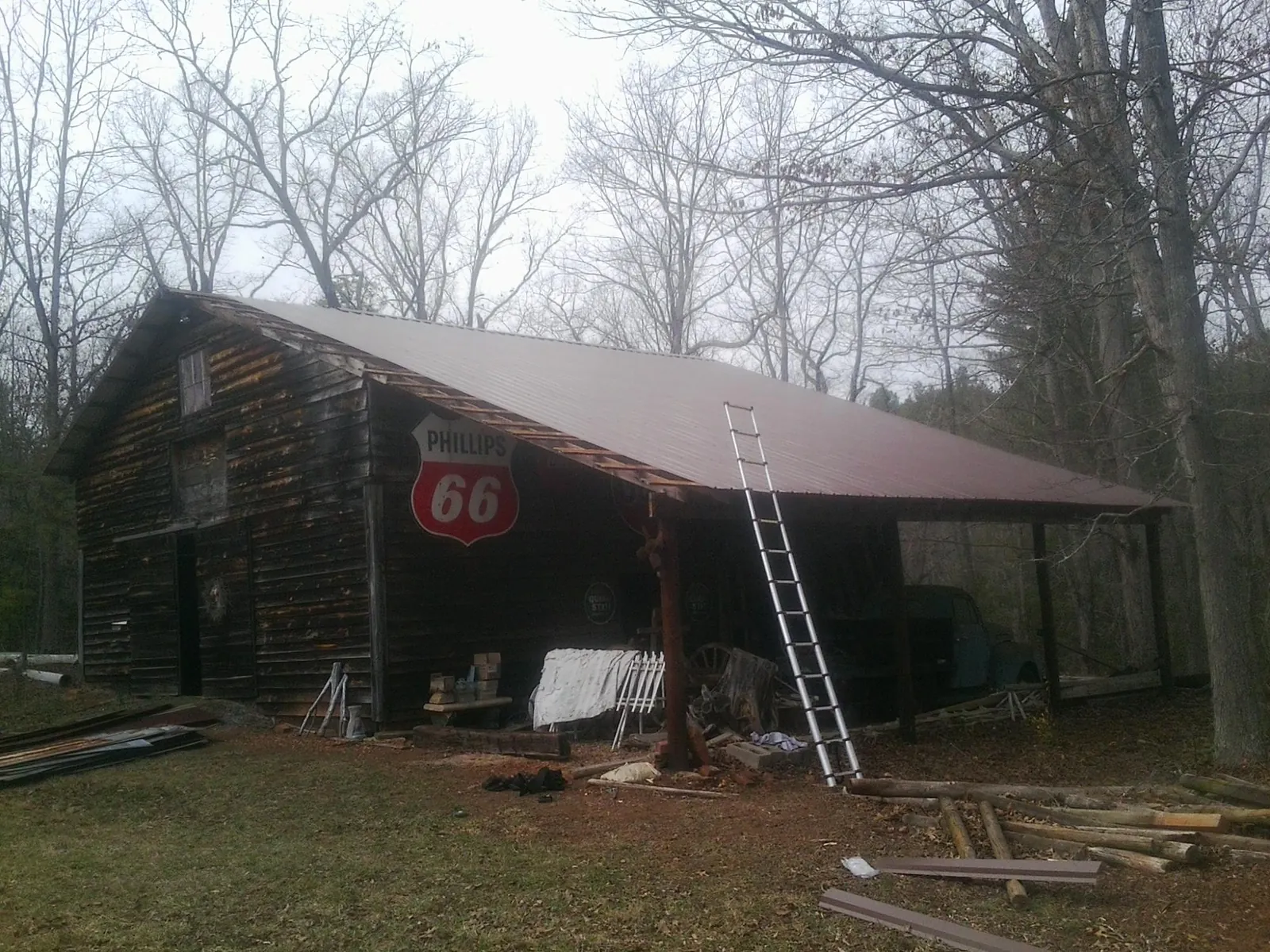 New metal roof on an open sided timber barn with a vintage sign in High Point