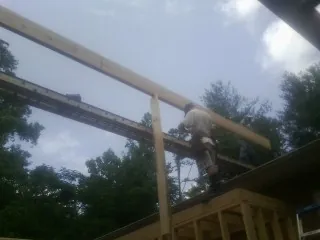 Carpenter setting a ridge beam over a new addition frame — Ice Dam Removal by Roofing Brothers in High Point