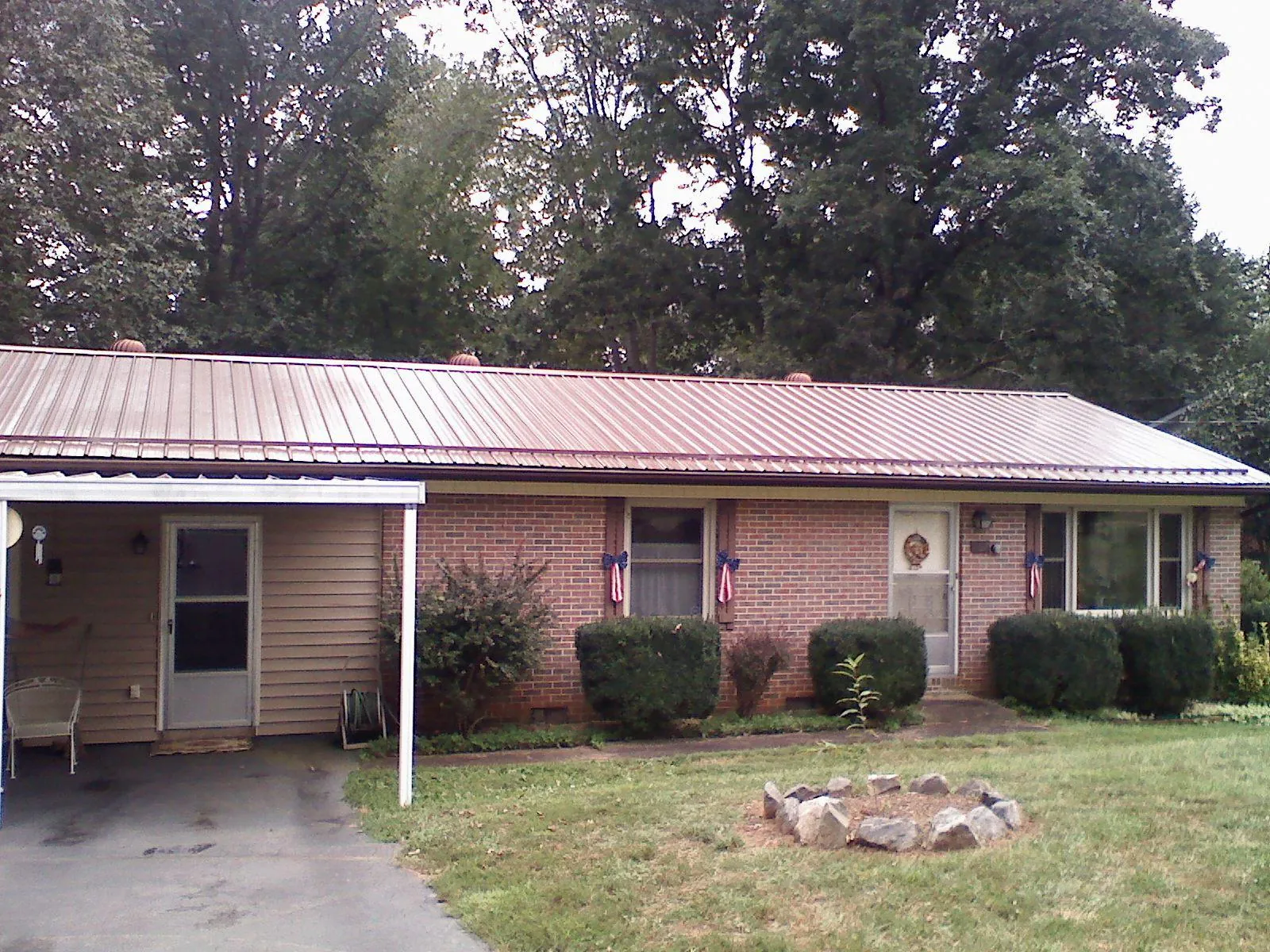 Bronze metal roof and carport on a brick ranch home — Roof Repair work by our crew in High Point