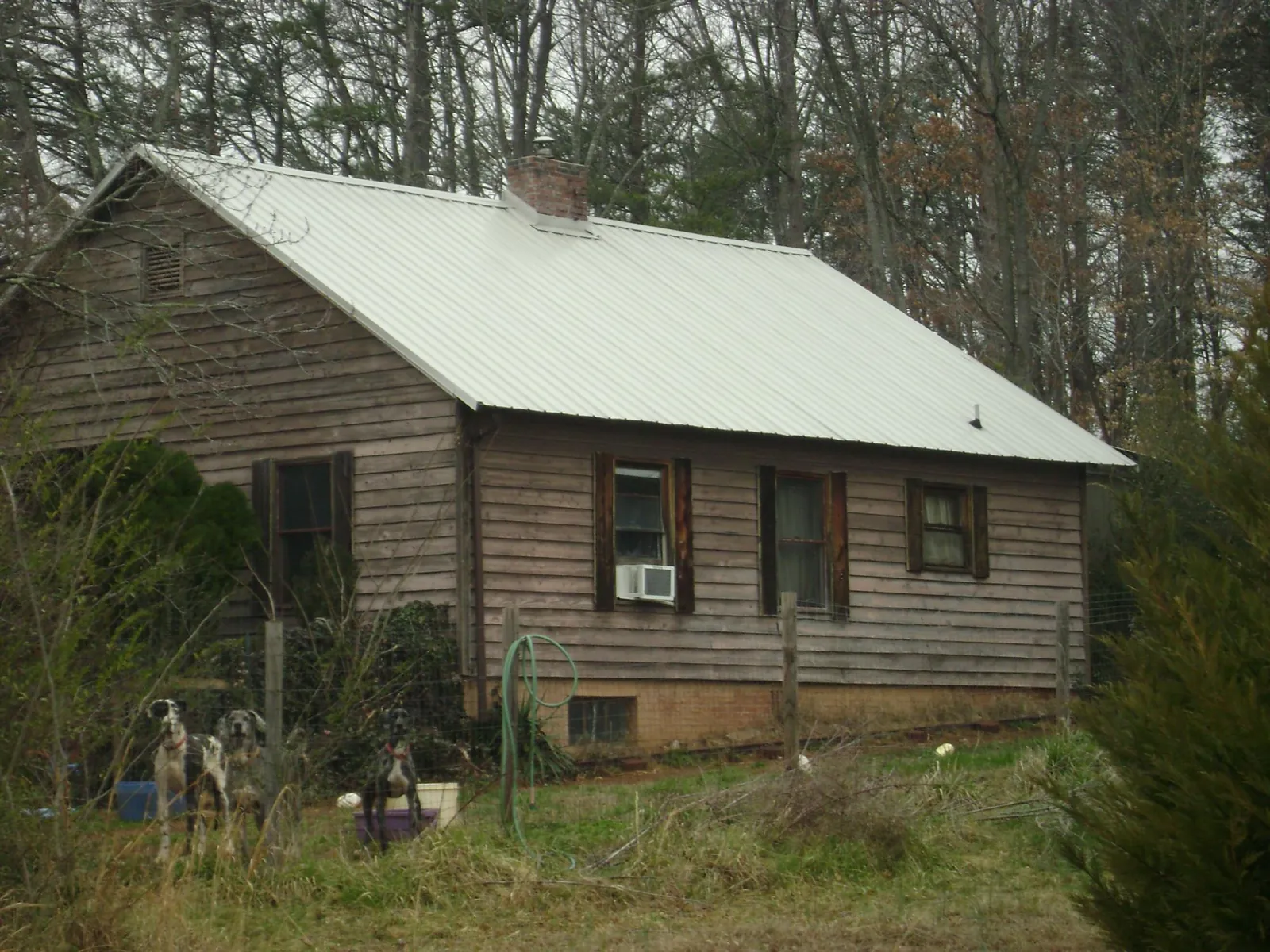 White metal roof on an old wood sided farmhouse, from a Metal Roof Installation job in High Point